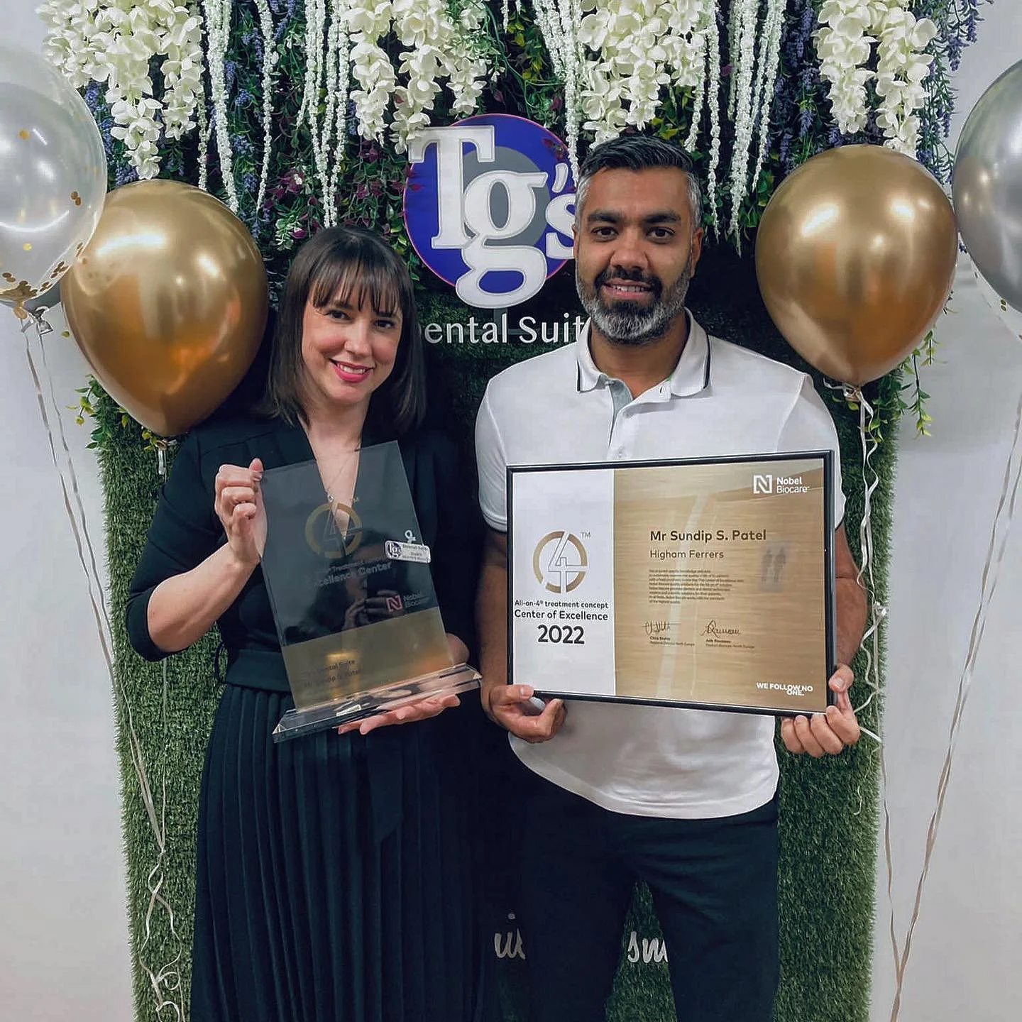 Principal Dentist Sundip Patel and a colleague holding TG's Dental Suite's Nobel Biocare All-on-4 Centre of Excellence award, Higham Ferrers, 2022