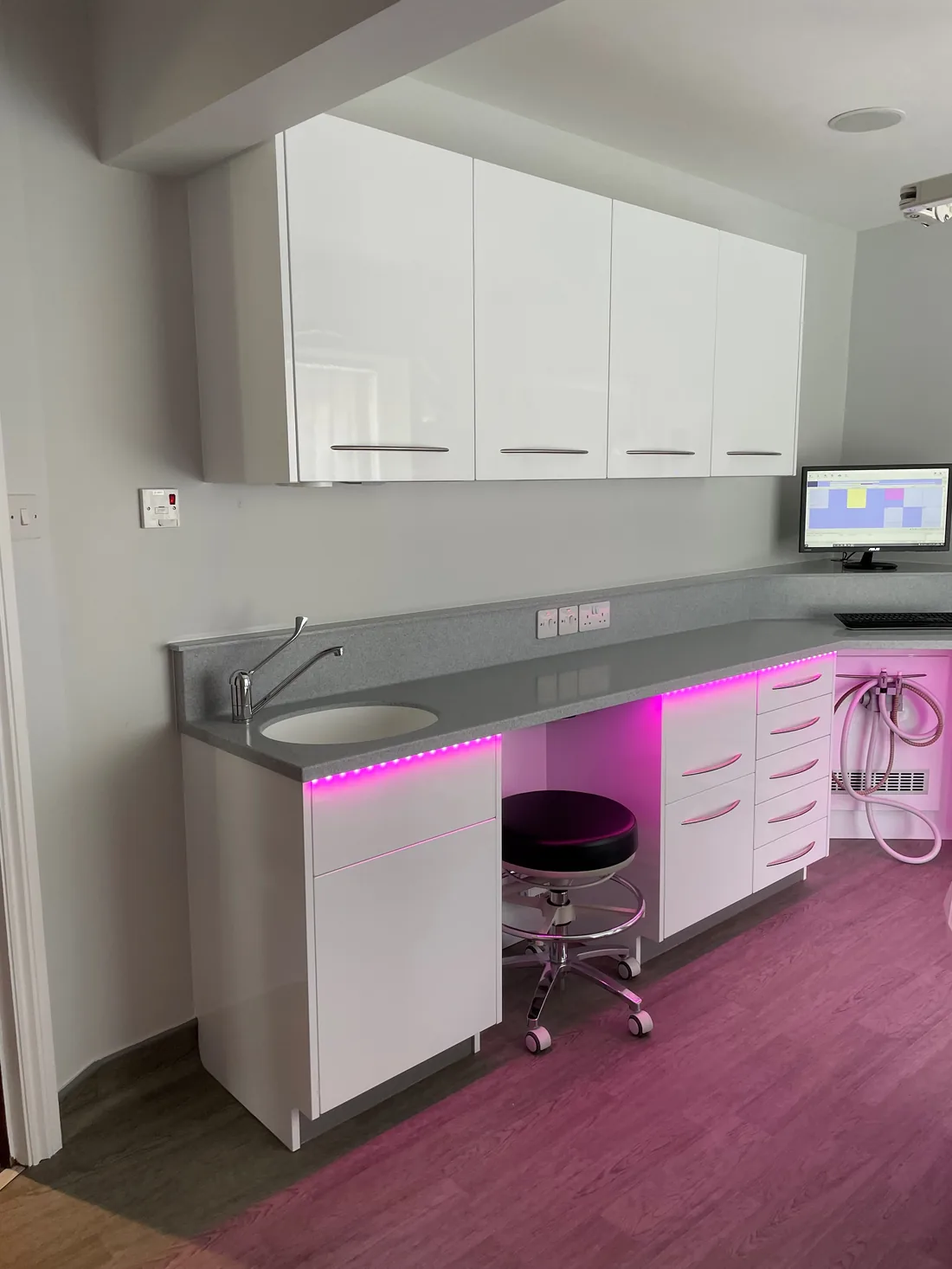A treatment room at one of our practices, with worktop, cabinetry and a clinician stool